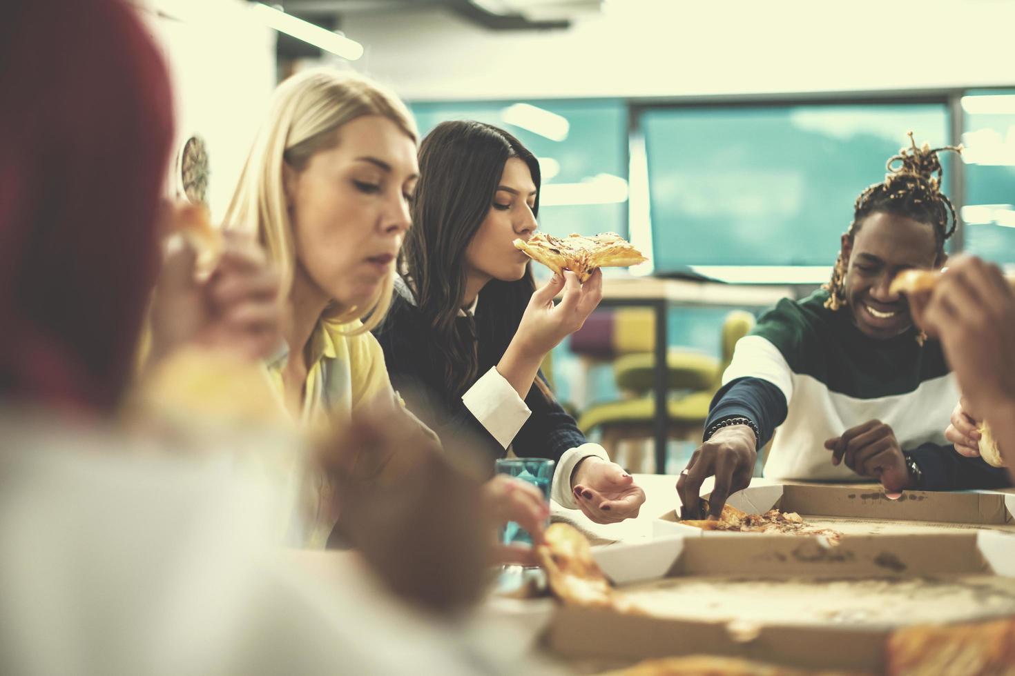 equipo de negocios multiétnico comiendo pizza foto