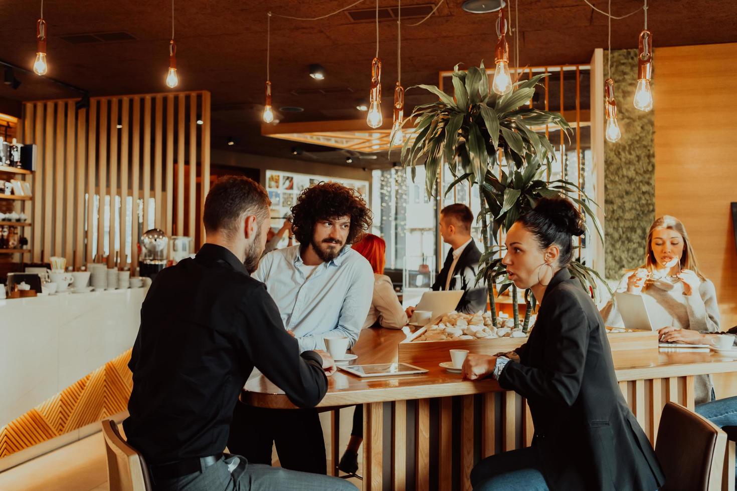 A group of friends hanging out in a cafe, and among them is a tablet. photo