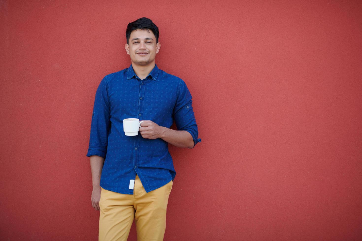 retrato de un hombre de negocios indio casual frente a una pared rosa foto