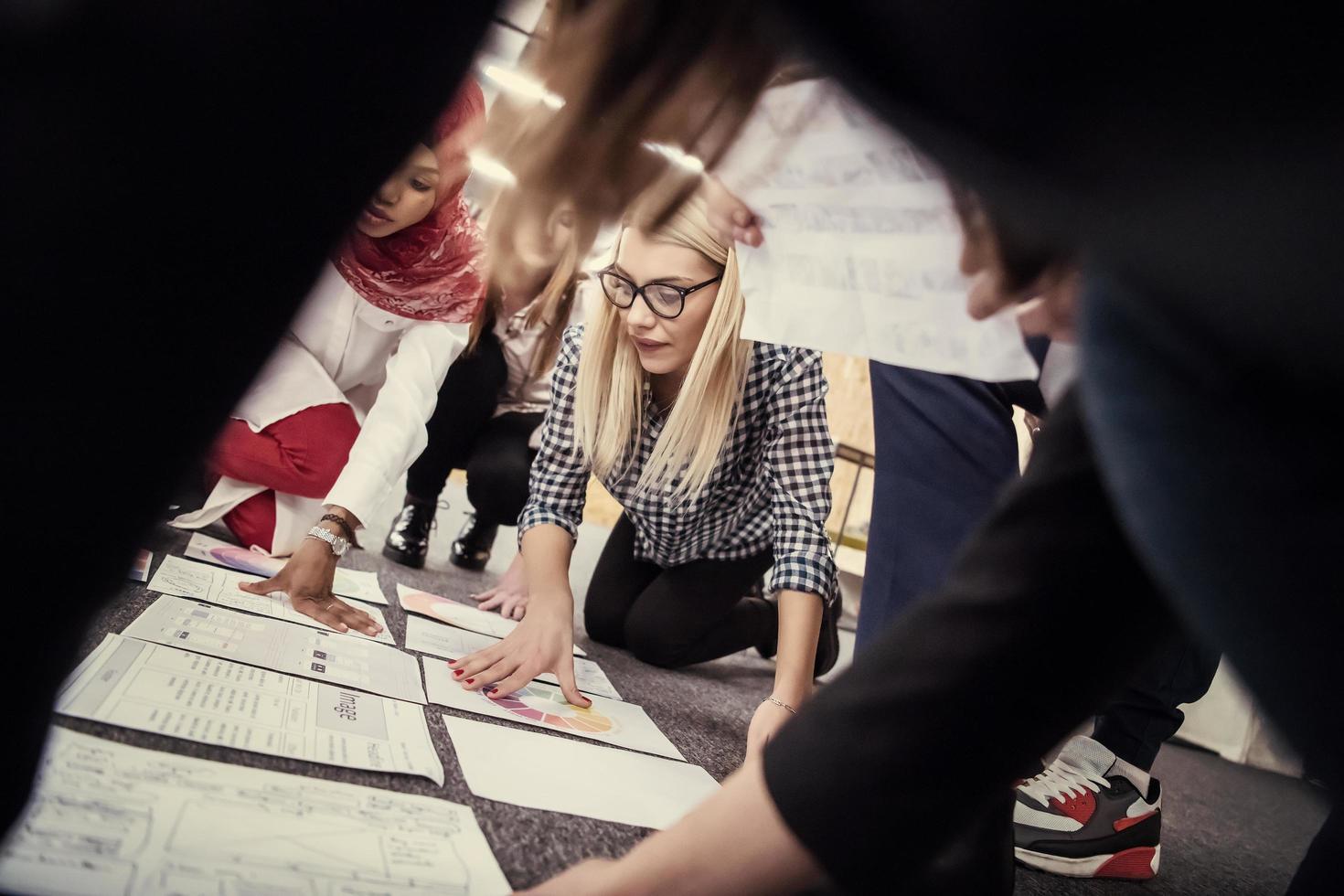 mujer de negocios rubia reunida con un equipo multiétnico de empresas emergentes foto