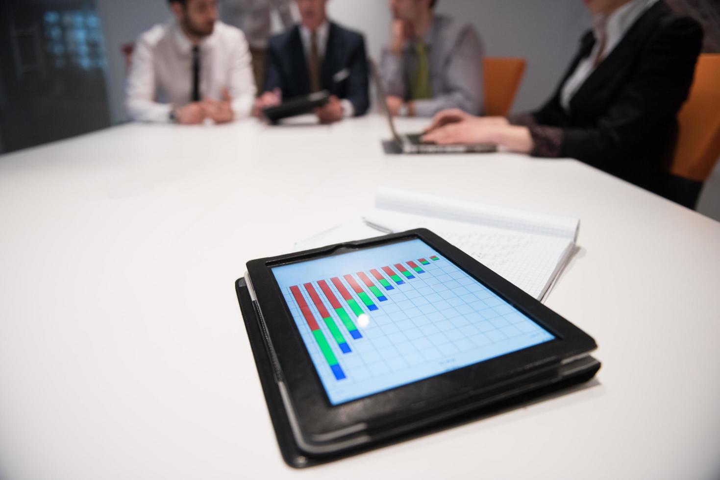 close up of touchpad with analytics documents at business meeting photo