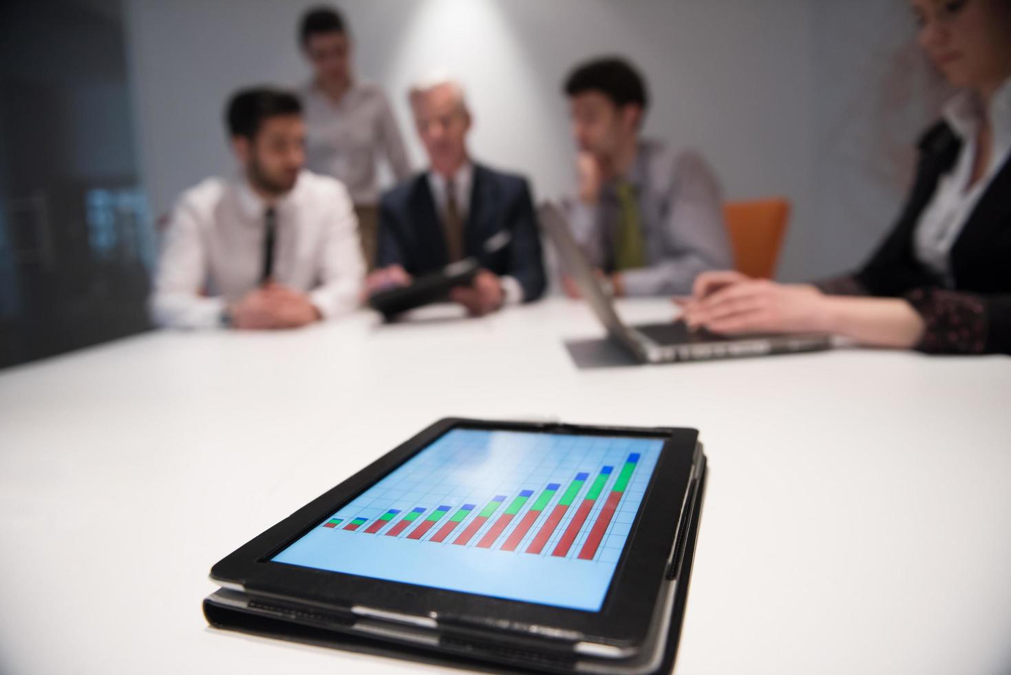 close up of touchpad with analytics documents at business meeting photo