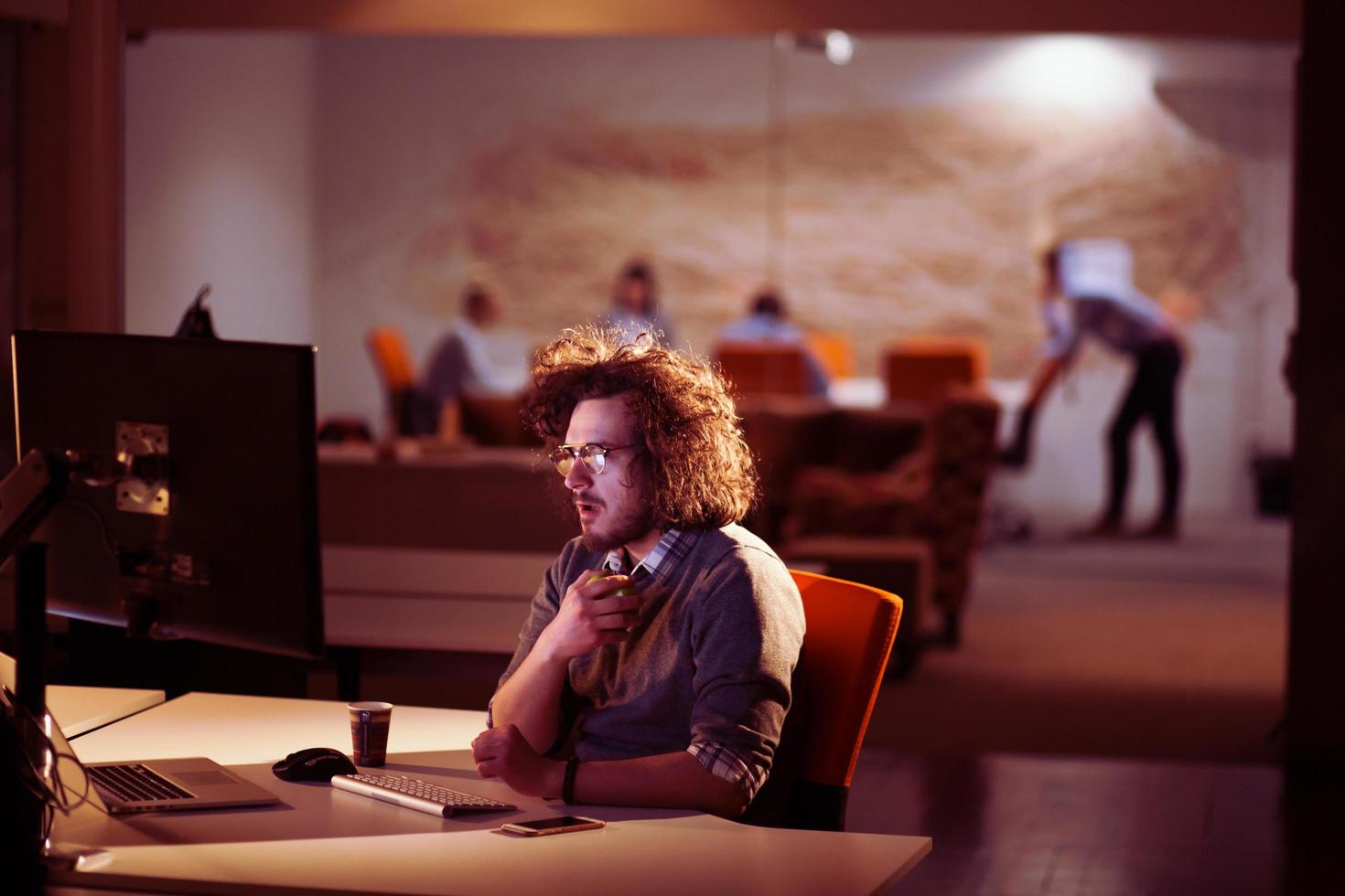 man working on computer in dark office photo