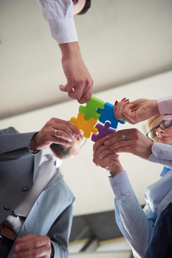 business people group assembling jigsaw puzzle photo