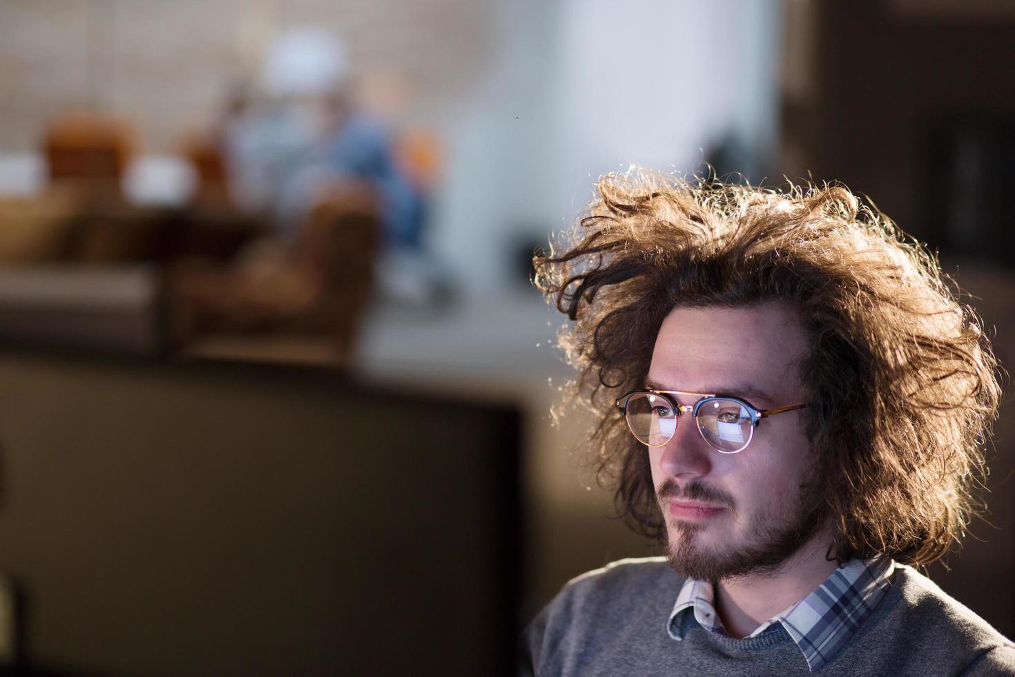 man working on computer in dark office photo