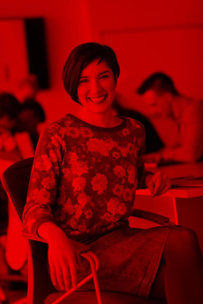 portrait of young business woman at office with team on meeting in background photo