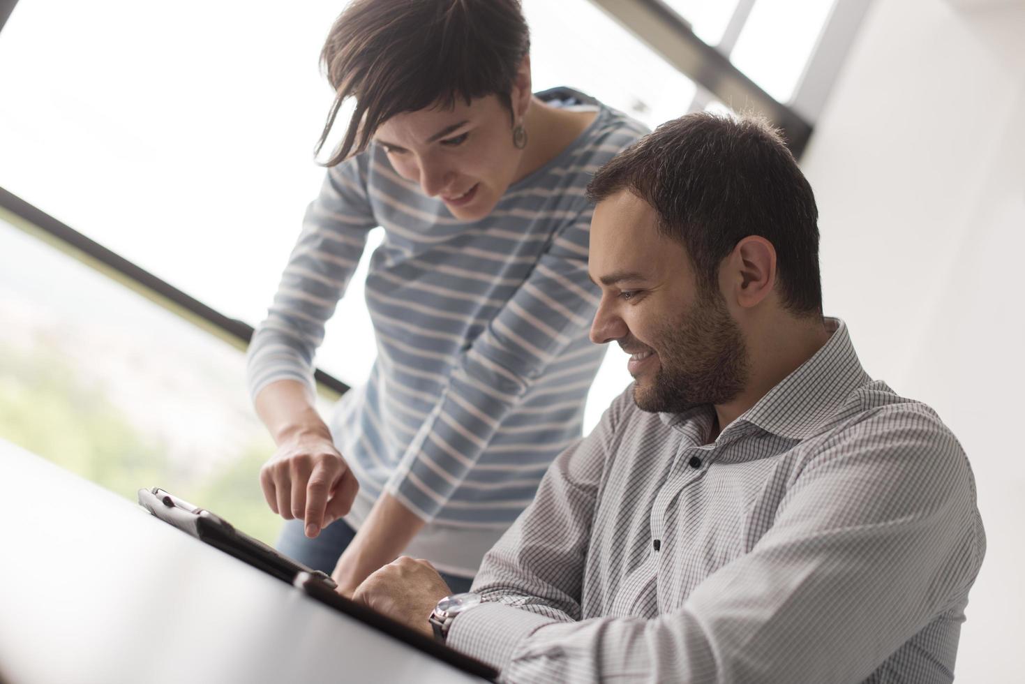 Two Business People Working With Tablet in startup office photo