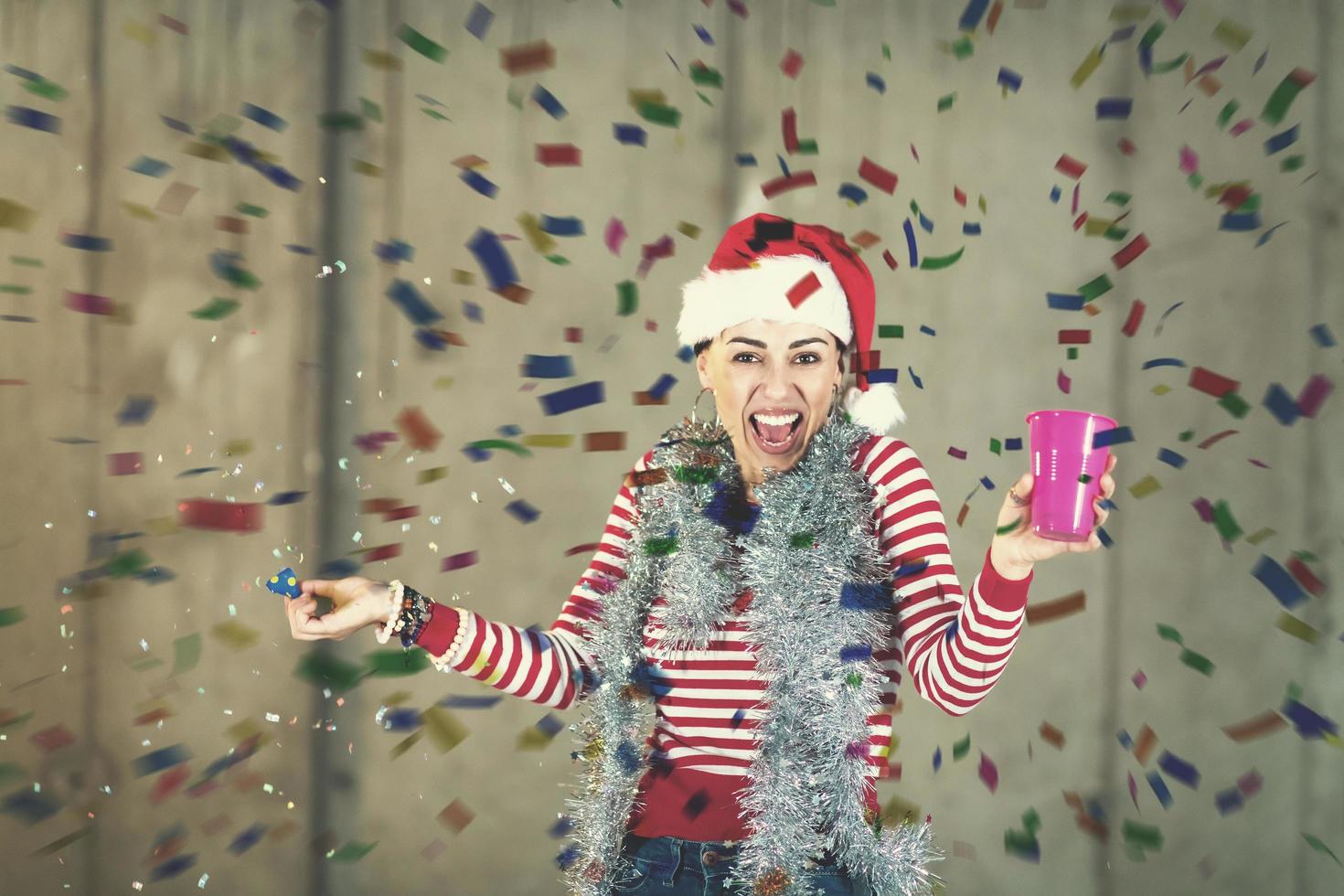 business woman wearing a red hat and blowing party whistle photo