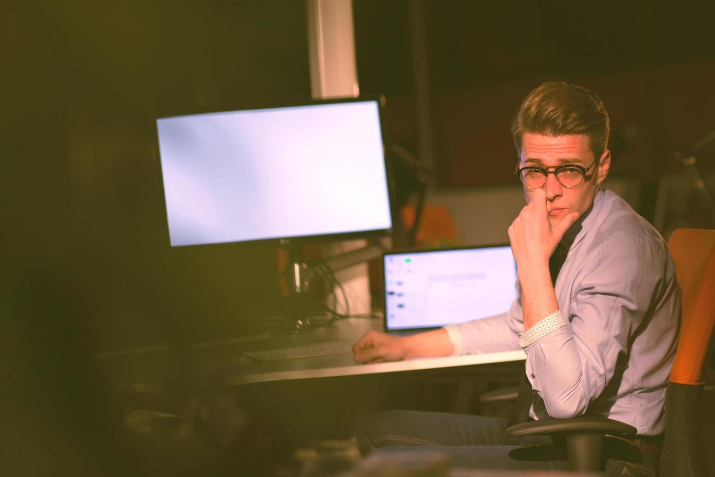 man working on computer in dark office photo