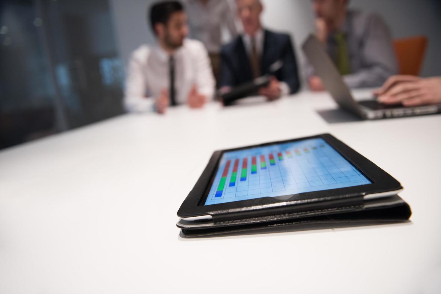 close up of touchpad with analytics documents at business meeting photo