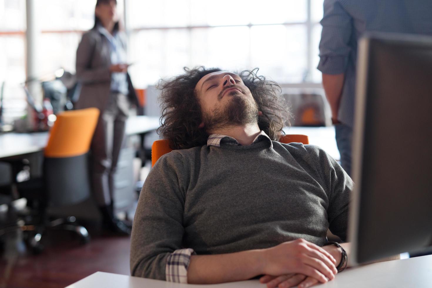 young businessman relaxing at the desk photo