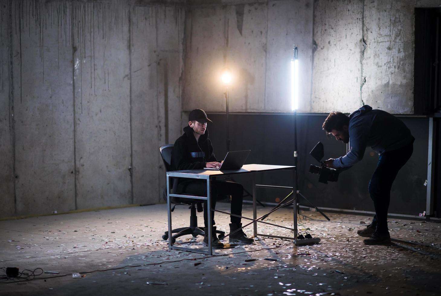 videographer recording talented hacker while working in dark office photo