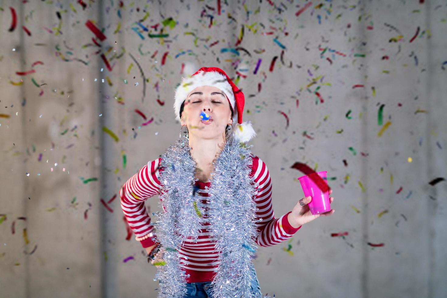 business woman wearing a red hat and blowing party whistle photo