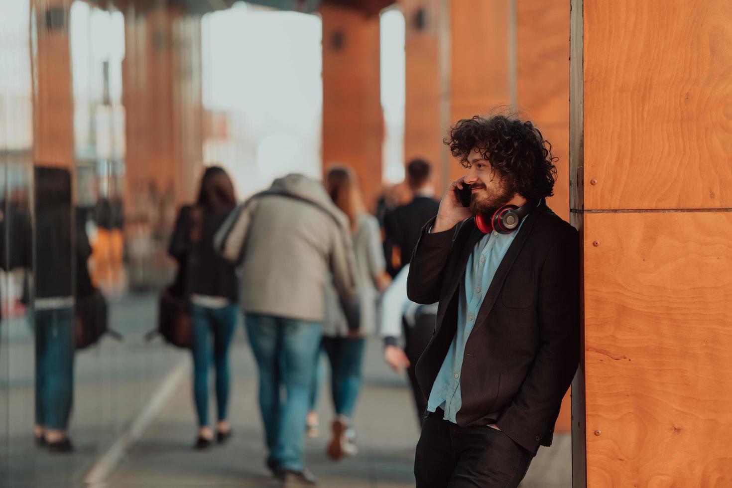 feliz joven americano sosteniendo un café. con auriculares chico estudiante foto