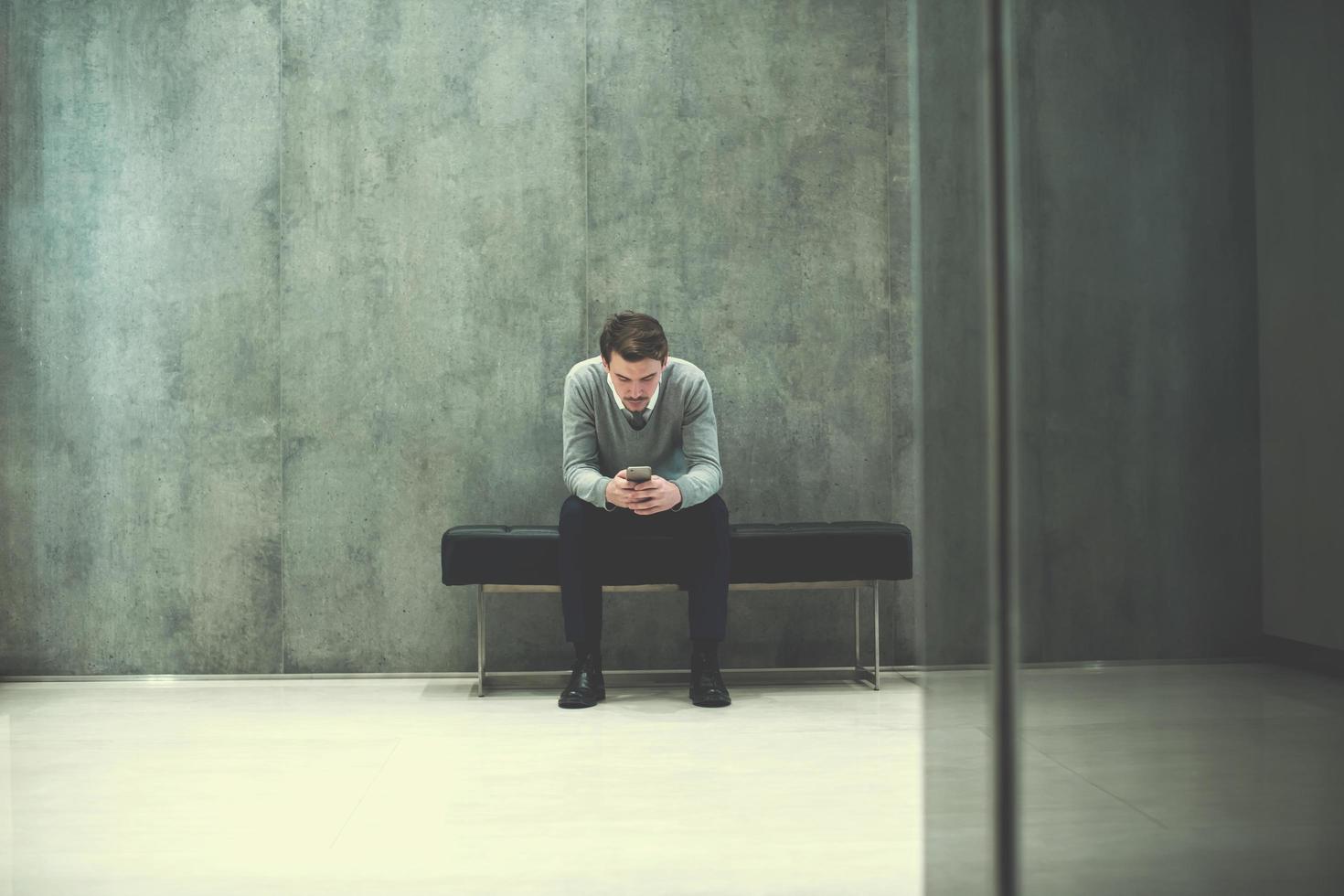 businessman using smart phone while sitting on the bench photo