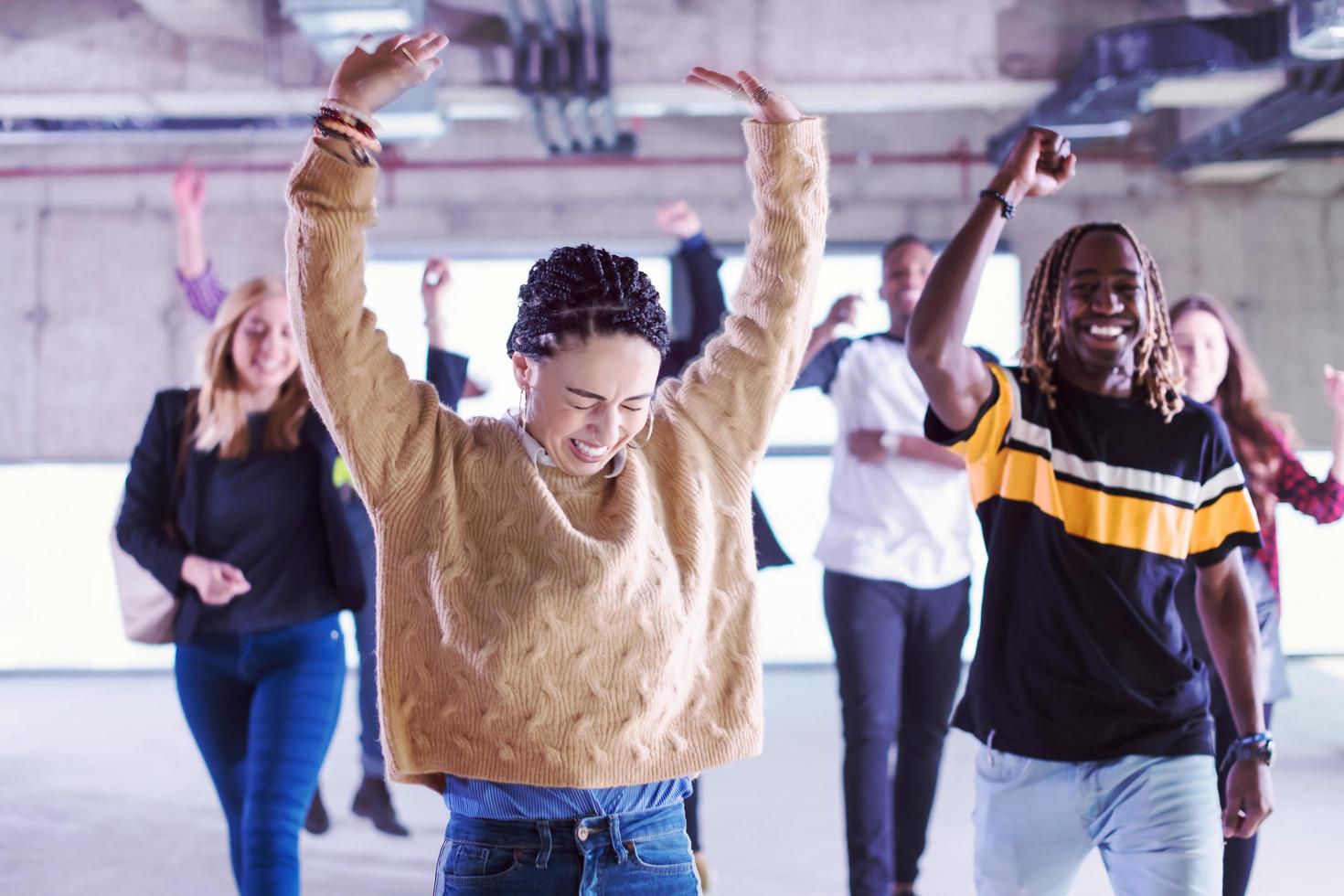 young multiethnic business people dancing in unfinished startup office photo