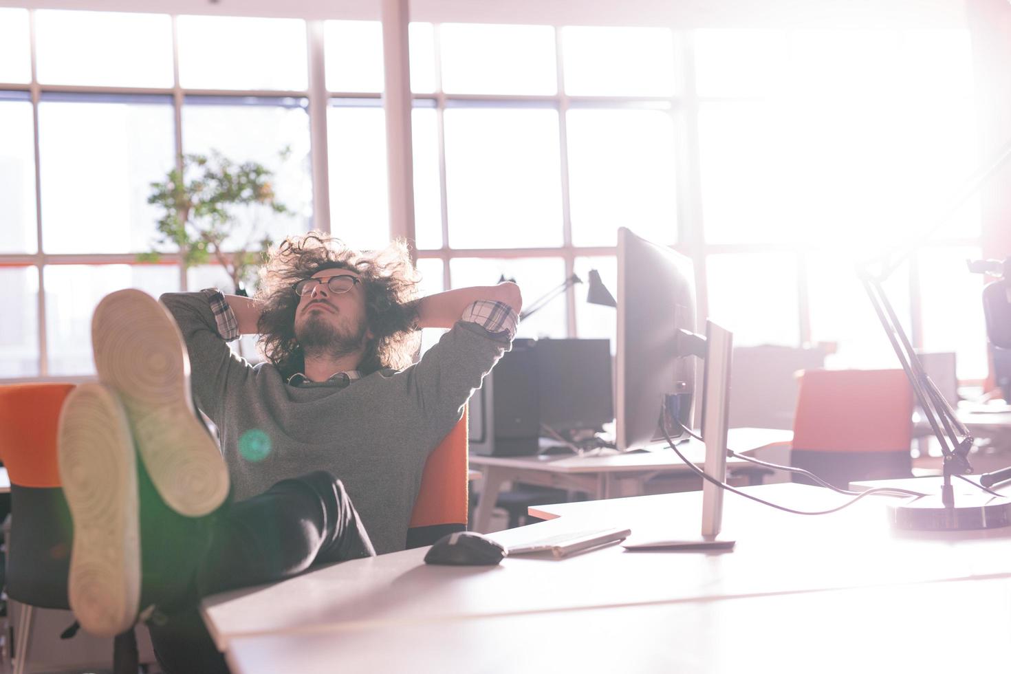 businessman sitting with legs on desk photo