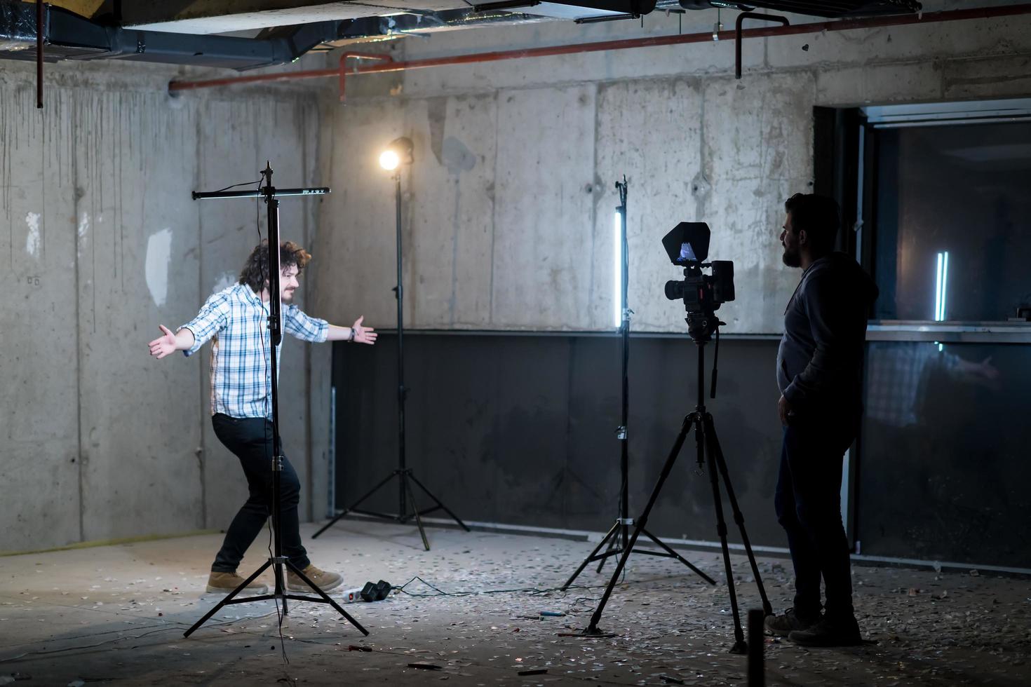 videographer recording casual businessman in front of a concrete wall photo
