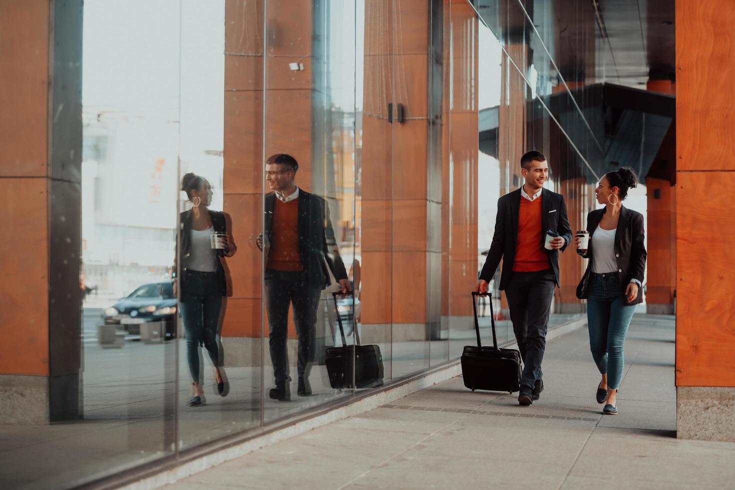 Business man and business woman talking and holding luggage traveling on a business trip photo