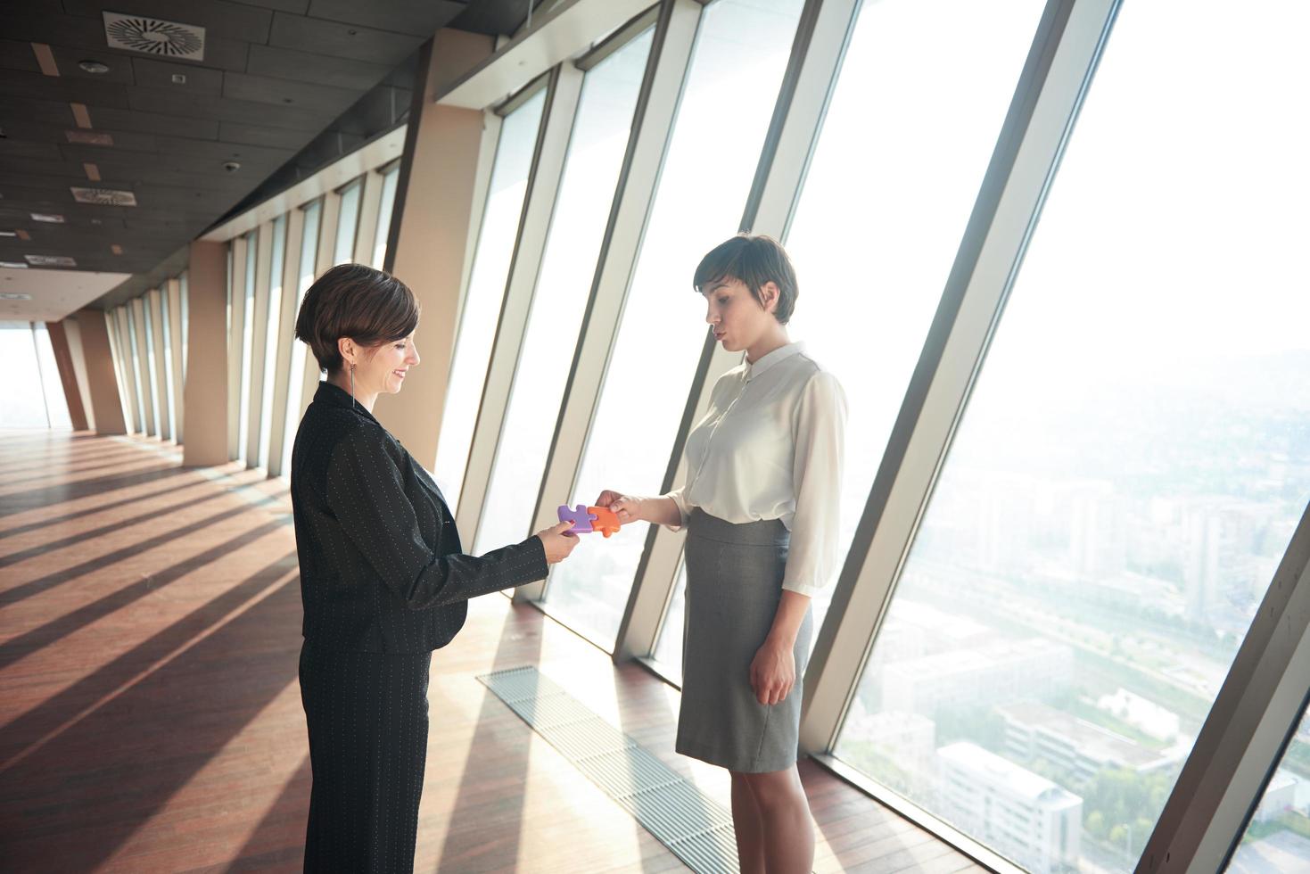 business woman group assembling jigsaw puzzle photo