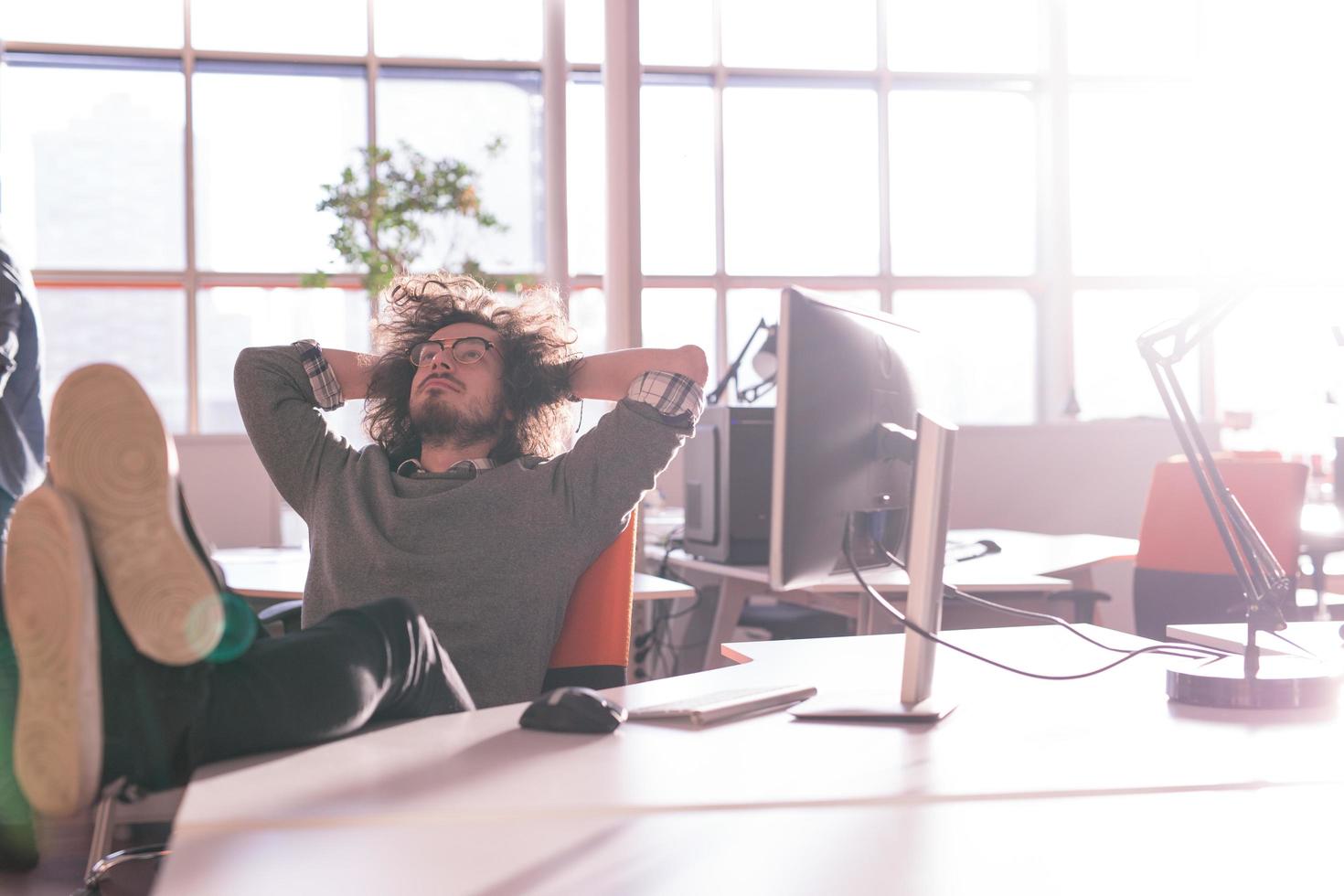 businessman sitting with legs on desk photo
