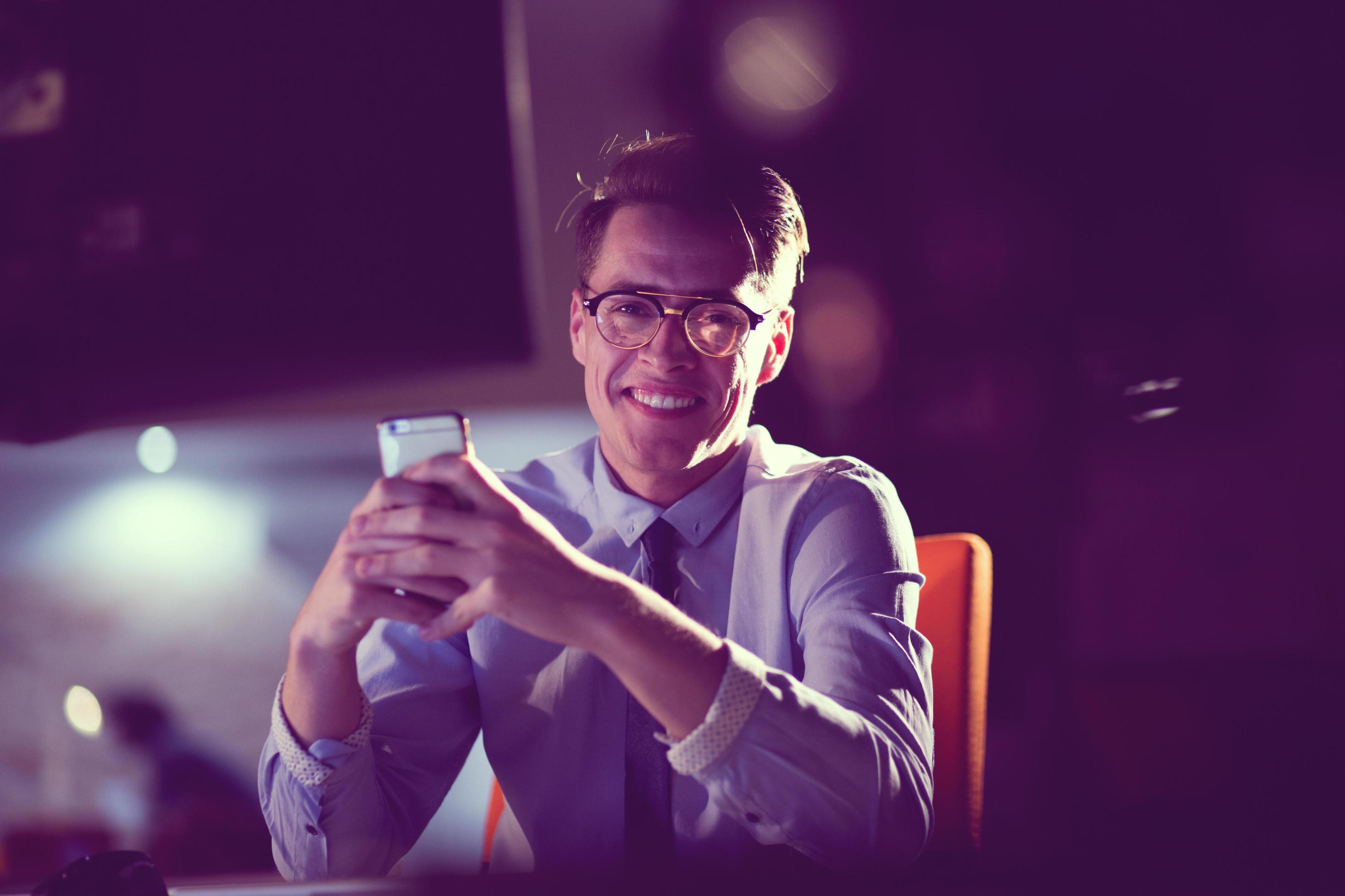man using mobile phone in dark office 12437366 Stock Photo at Vecteezy