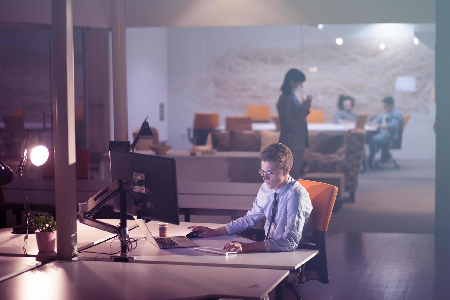 man working on computer in dark office photo