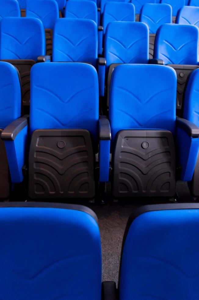 salón con filas de asientos azules foto