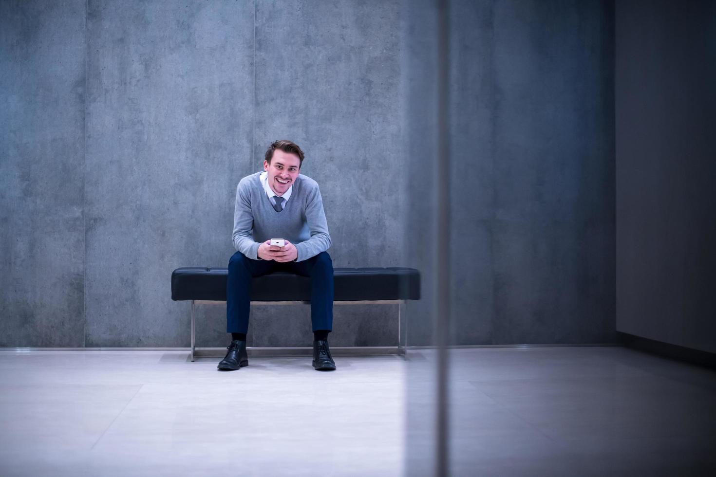 businessman using smart phone while sitting on the bench photo