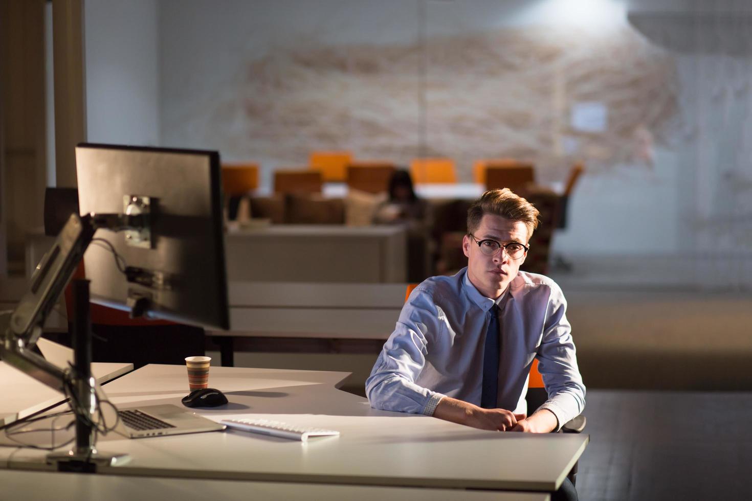 man working on computer in dark office photo