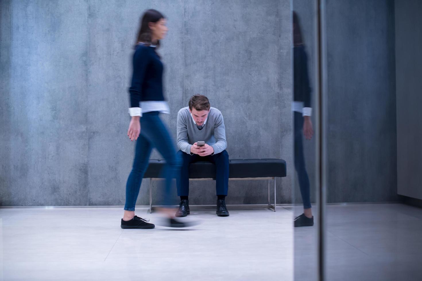 businessman using mobile phone while sitting on the bench photo