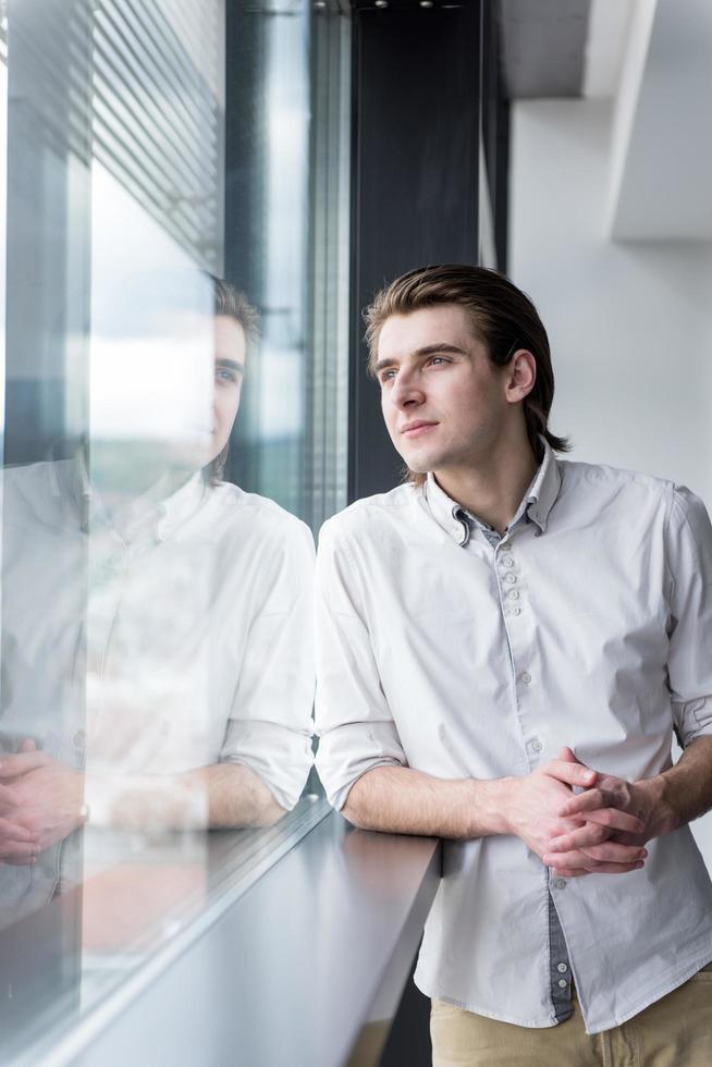 joven empresario en la oficina de inicio junto a la ventana foto