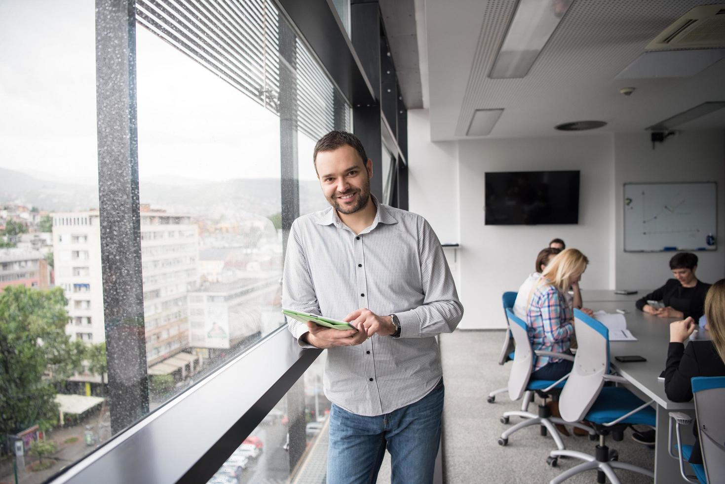 Businessman Using Tablet In Office Building by window photo