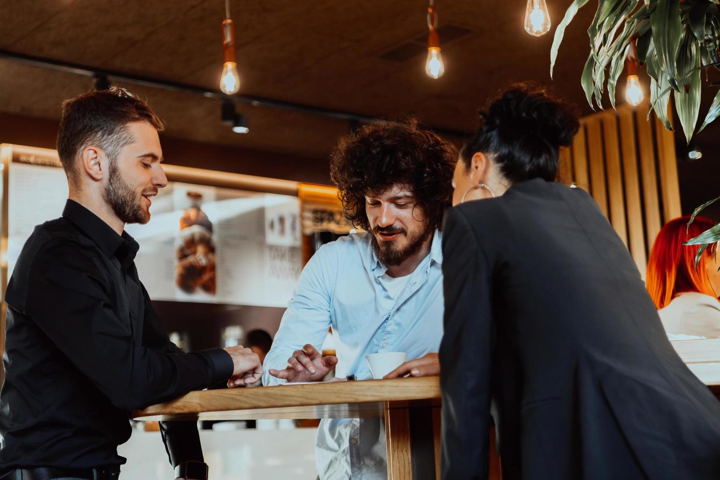 A group of friends hanging out in a cafe, and among them is a tablet. photo