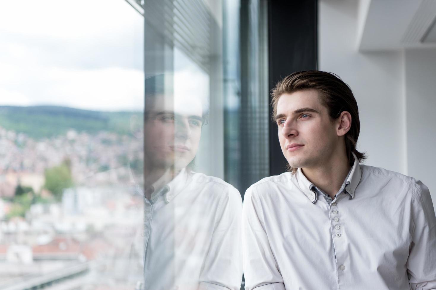 joven empresario en la oficina de inicio junto a la ventana foto