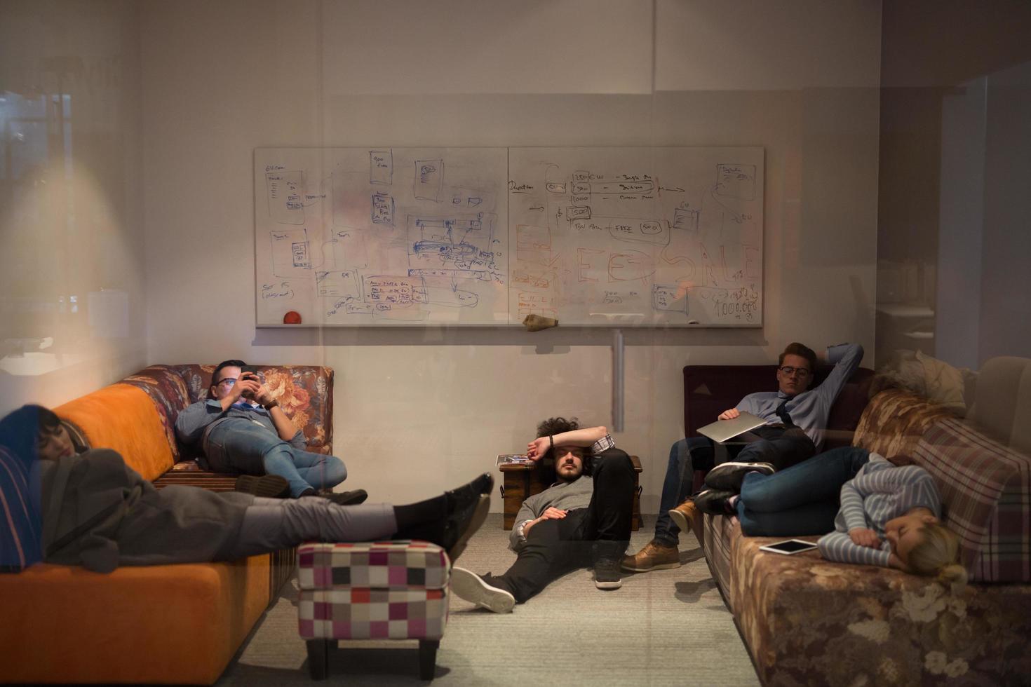 software developers sleeping on sofa in creative startup office photo