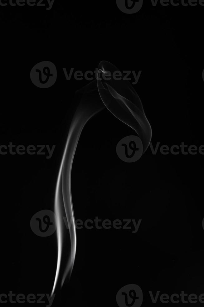 A single white smoke burn from incense, shot in studio with dark black background, for design and religion concept photo