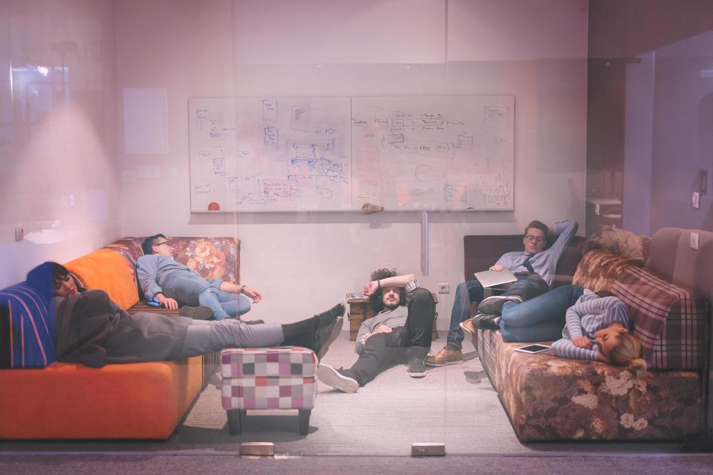 software developers sleeping on sofa in creative startup office photo