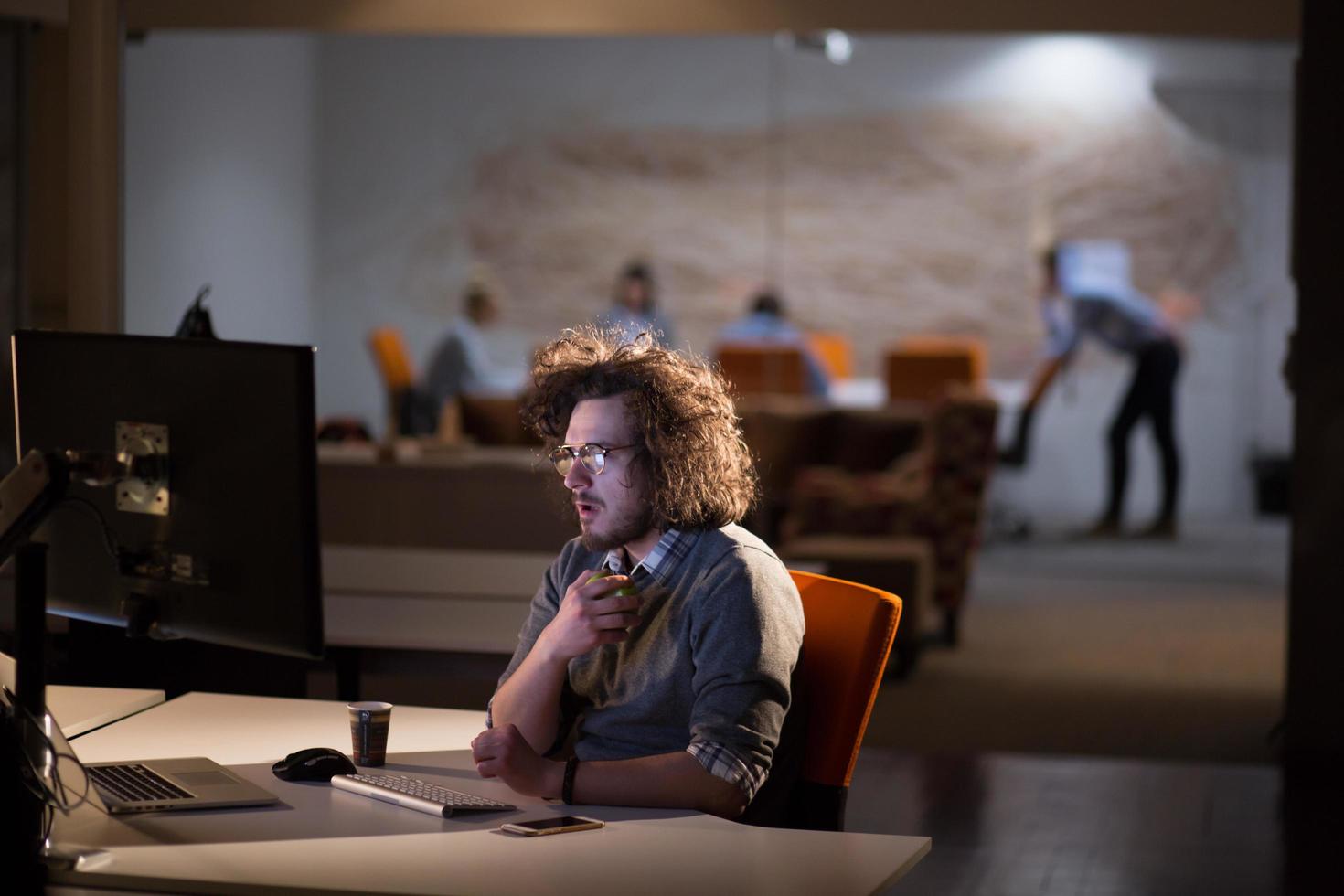 man working on computer in dark office photo