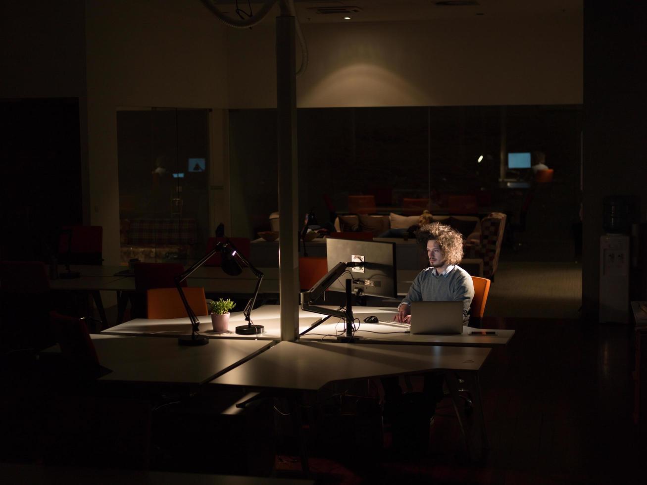man working on computer in dark office photo