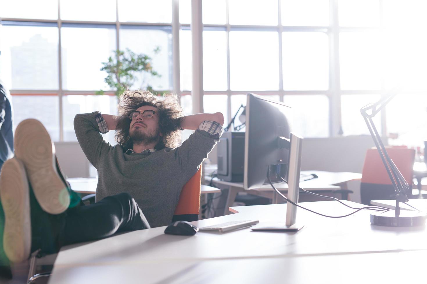 businessman sitting with legs on desk photo