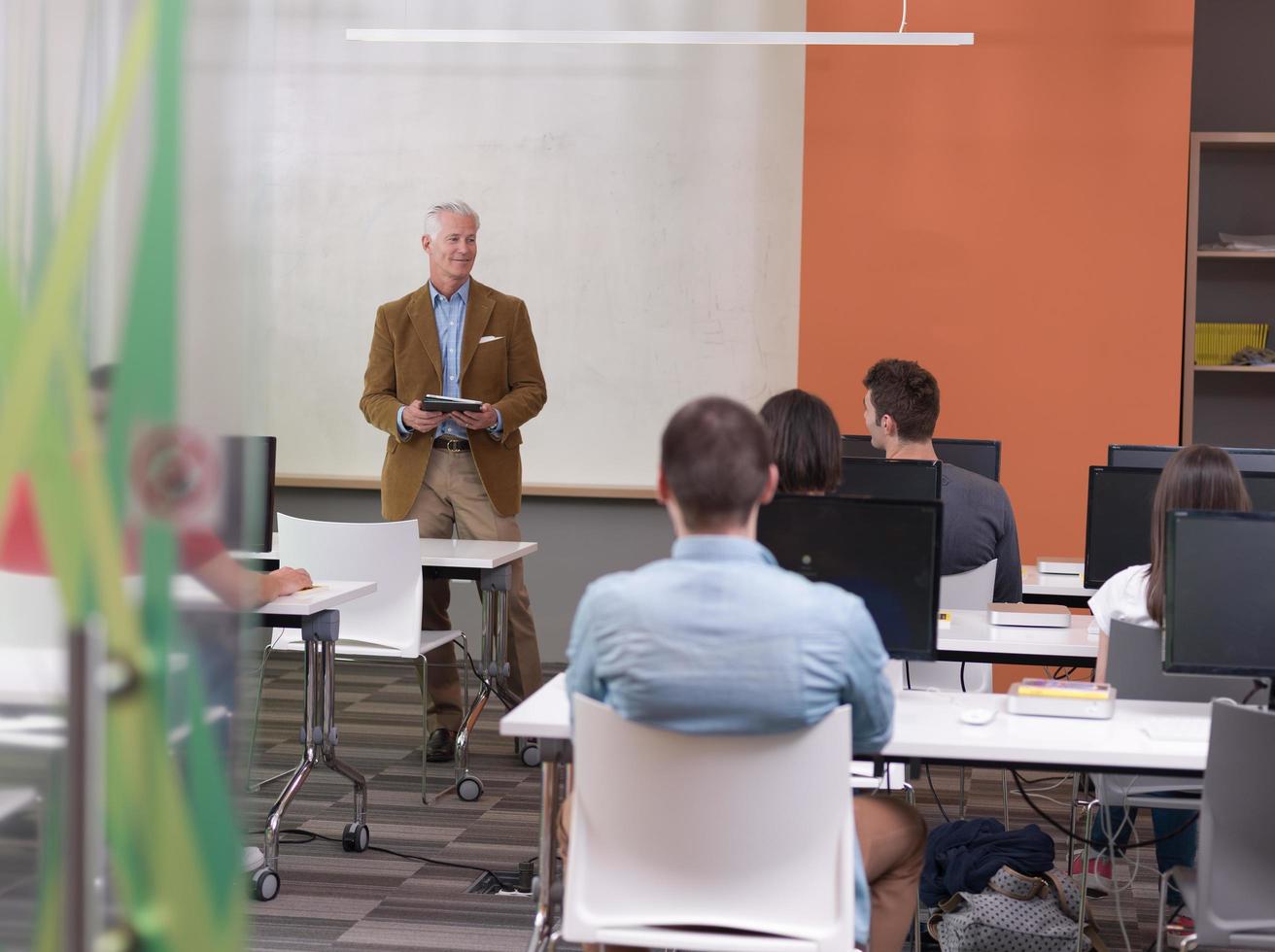 senior teacher and students group in computer lab classroom photo
