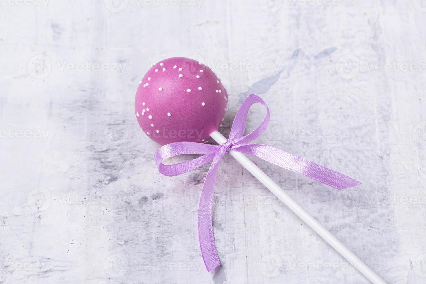 A purple cake pop on a textured background photo