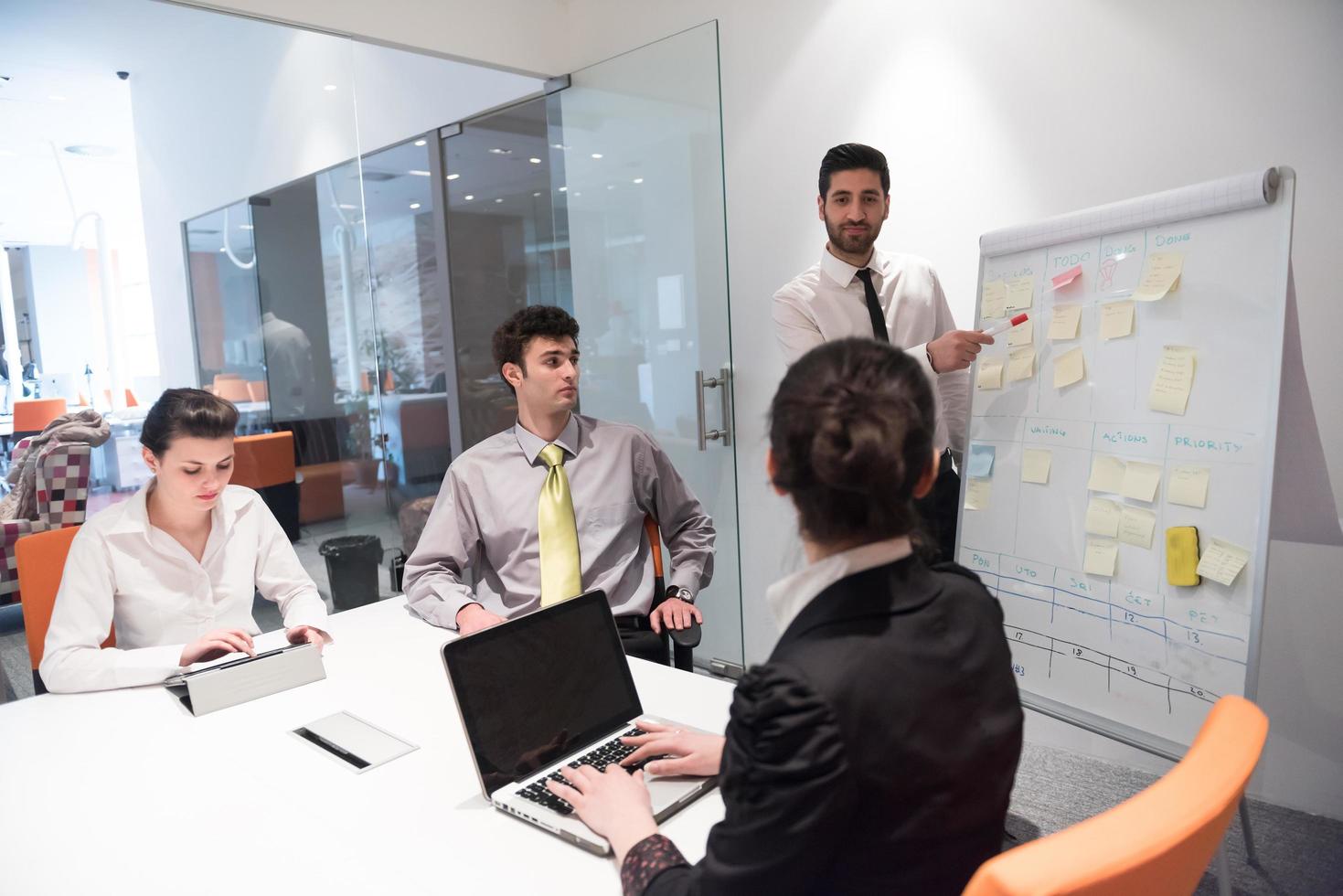 business people group brainstorming and taking notes to flip board photo