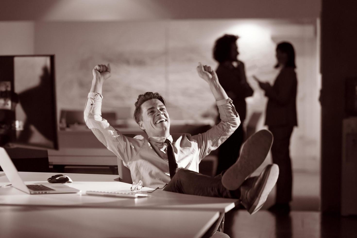 businessman sitting with legs on desk at office photo