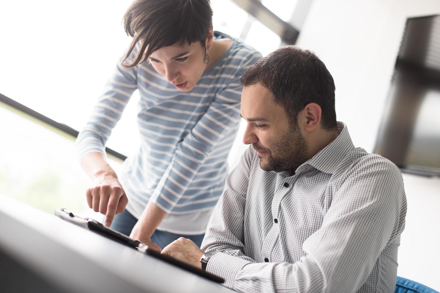 Two Business People Working With Tablet in startup office photo