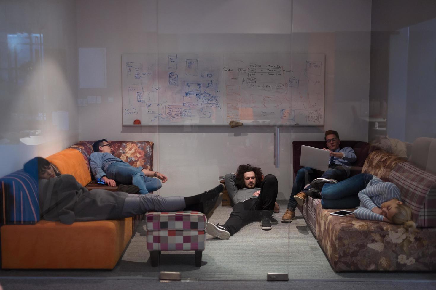 software developers sleeping on sofa in creative startup office photo