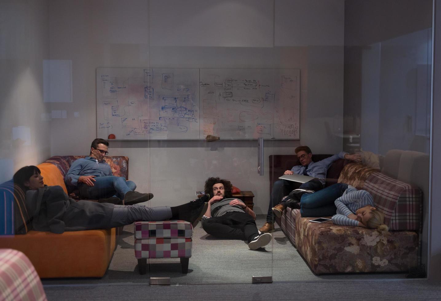 software developers sleeping on sofa in creative startup office photo