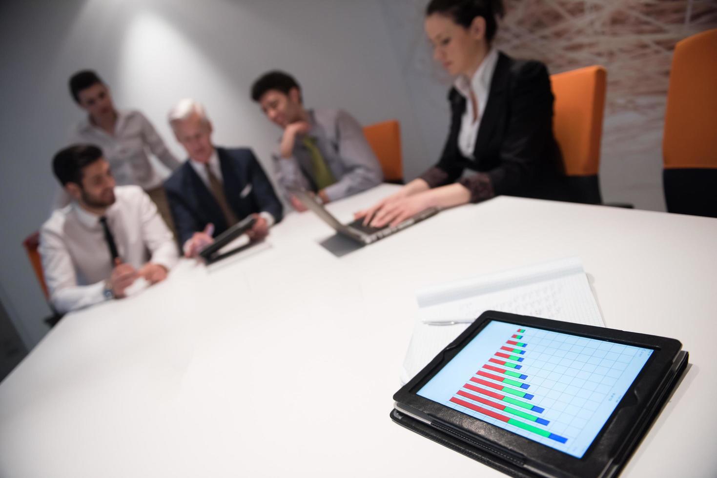 close up of touchpad with analytics documents at business meeting photo