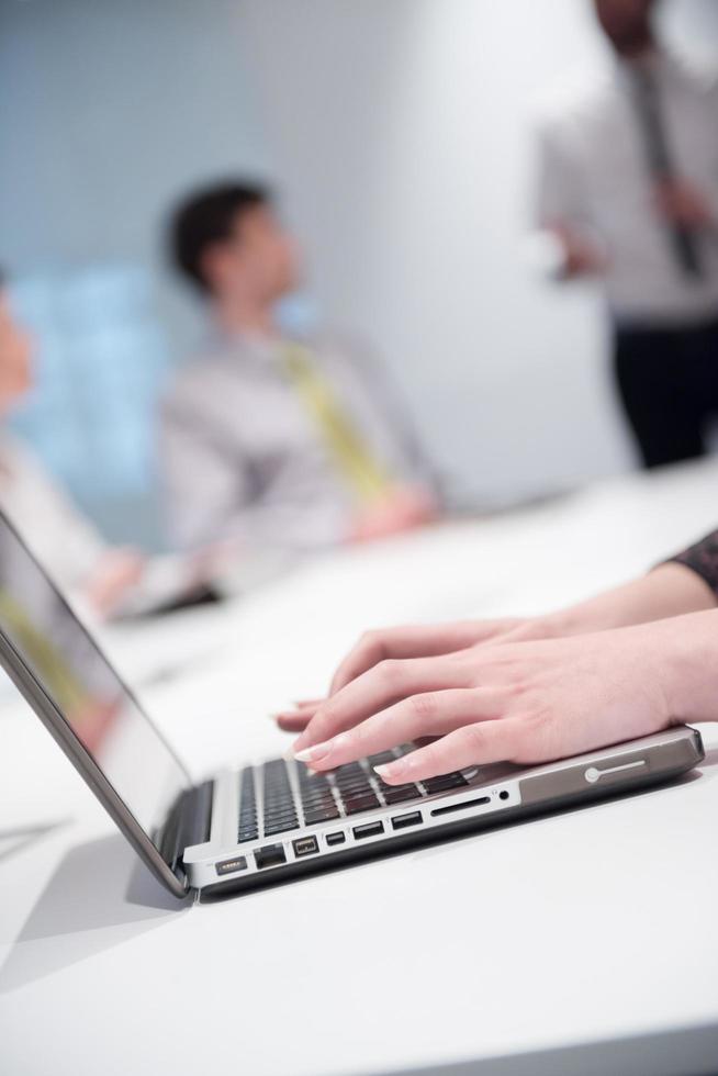 woman hands typing on laptop keyboard at business meeting photo